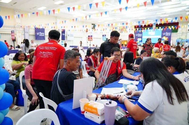 Alagang Unilab Health Community health event with attendees seated, banners reading "Alagang Unilab," and colorful decorations in a gymnasium.